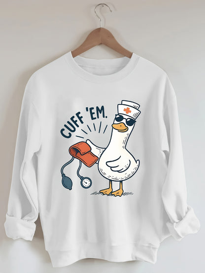 A cozy pink “Silly Goose” nurse sweatshirt featuring a cute duckling and bold CUFF ’EM slogan, perfect for winter shifts and everyday scrubs style.